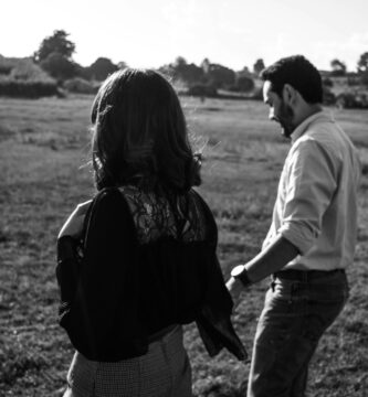 a man and a woman standing in a field